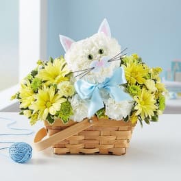 Cat-shaped flower basket with yellow and white blooms and a blue bow