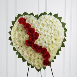 Heart-shaped white floral wreath with a diagonal line of red roses