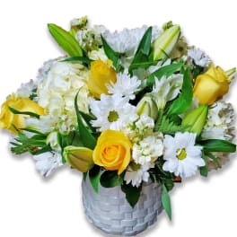 Yellow roses and white daisies in a woven silver vase