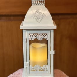White decorative lantern with a glowing candle inside