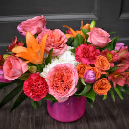 Pink and orange mixed bouquet in a magenta vase