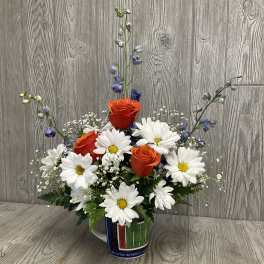 Orange roses and white daisies in a Florida mug vase