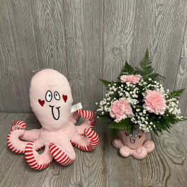 Pink plush octopus beside a pink carnation bouquet in a novelty mug
