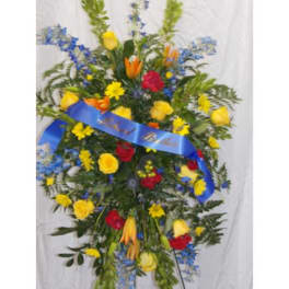 Standing floral spray with yellow, red, blue, and orange flowers on a blue ribbon
