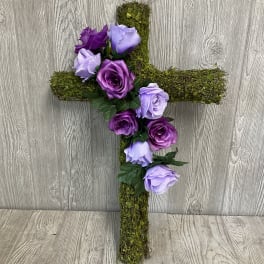 Moss-covered cross with purple and lavender roses