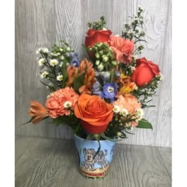 Mixed bouquet of orange and red flowers in a decorative vase