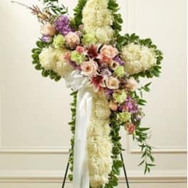 Large floral standing spray with white and pink flowers on a white ribbon