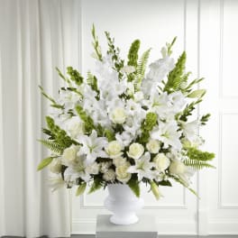 White floral arrangement in a white pedestal vase