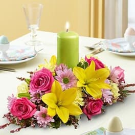 Bright floral centerpiece with pink roses and yellow lilies on a table