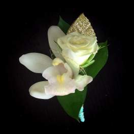 White rose and orchid boutonniere with green leaves and gold accent