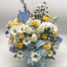 White daisies and yellow pompons in a blue vase with a baby boy balloon