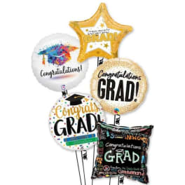 Graduation balloons with congratulatory messages and a black grad pillow