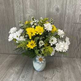 Yellow and white daisy bouquet in a pale vase