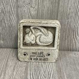 Stone memorial plaque with a sleeping cat and paw print text