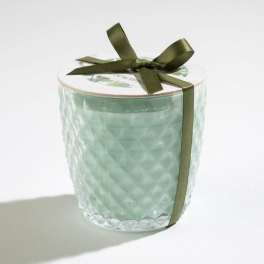 Pale green candle in a textured glass jar with a round lid and green ribbon bow