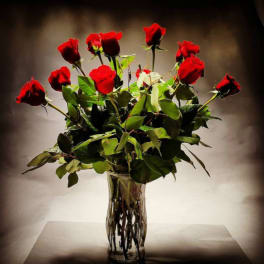 Red roses arranged in a clear glass vase