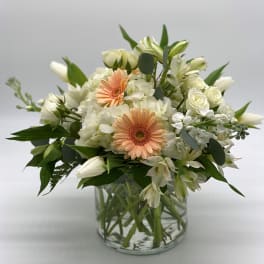 White and peach mixed bouquet in a clear glass vase