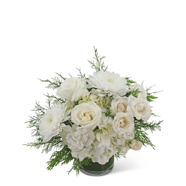 White roses and chrysanthemums in a glass vase with greenery