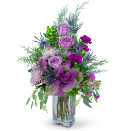 Purple and pink floral arrangement in a clear glass vase