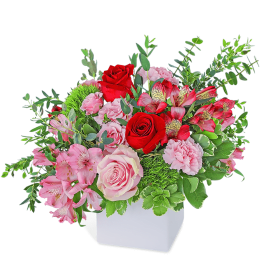 Pink and red flower arrangement in a white vase