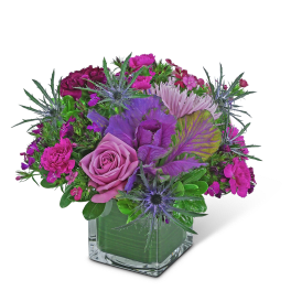 Pink and purple bouquet in a square glass vase