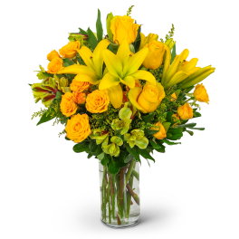 Yellow roses and lilies in a clear glass vase