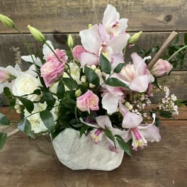 Pink and white orchid bouquet in a textured white vase