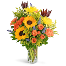 Mixed bouquet of sunflowers, orange roses, and a clear glass vase