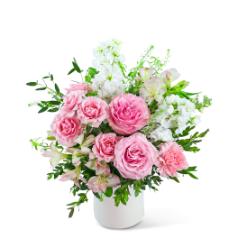 Pink roses and white flowers arranged in a white vase