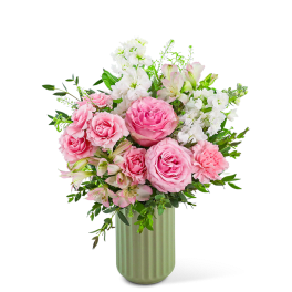 Pink roses and white flowers arranged in a green vase