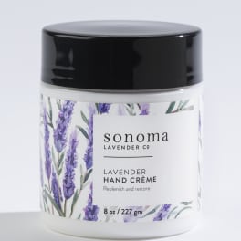 Jar of lavender hand creme with black lid and illustrated lavender sprigs on the label