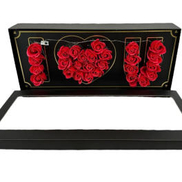 Black gift box with red roses arranged to spell I heart U inside the lid