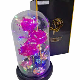 Artificial pink roses with LED lights inside a glass dome on a black base beside a black gift box