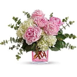 Pink peonies and white hydrangeas in a pink glass vase