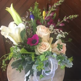 Mixed bouquet with roses, lilies, and purple blooms in a vase