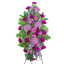 Tall standing spray of pink and purple flowers on a black easel