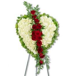 Heart-shaped floral spray with red roses and white hydrangeas on a stand