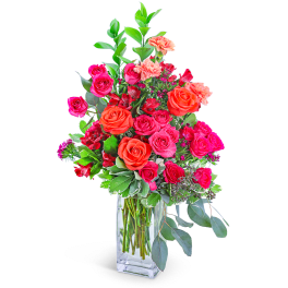 Pink and orange roses in a clear glass vase