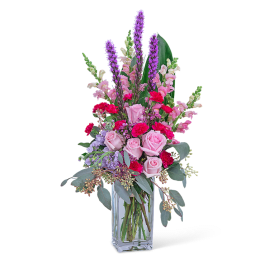 Pink and purple mixed flower arrangement in a clear glass vase
