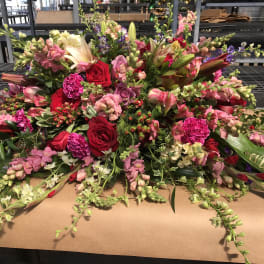 Large mixed floral arrangement with red, pink, and white blooms