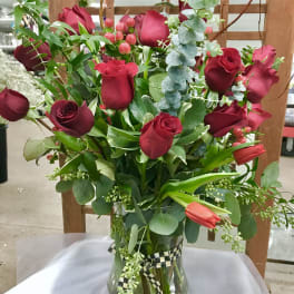 Bouquet of red roses and tulips in a glass vase