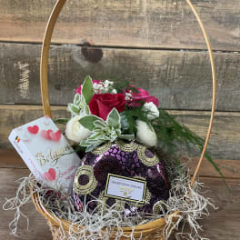 Basket of red and white roses with chocolates and a heart-shaped gift