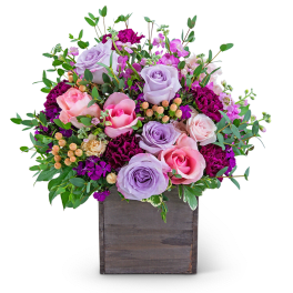 Lavender and pink roses in a wooden box with greenery