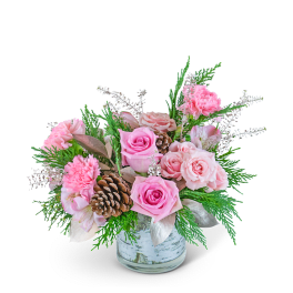 Pink roses and carnations in a glass vase with pinecones