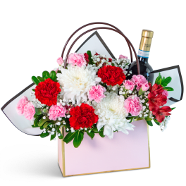 Flower gift basket with carnations, chrysanthemums, and a wine bottle