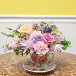 Pastel flower arrangement in a floral teacup and saucer