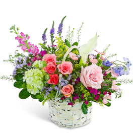 Mixed bouquet in a white wicker basket with pink roses and a white calla lily