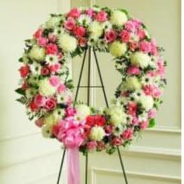 Large floral wreath on an easel with pink and white flowers