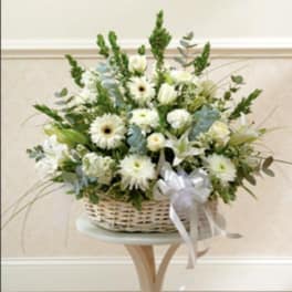 White floral basket arrangement with a ribbon bow