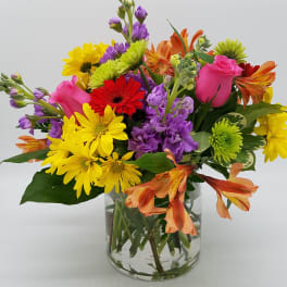 Mixed bouquet of colorful flowers in a clear glass vase